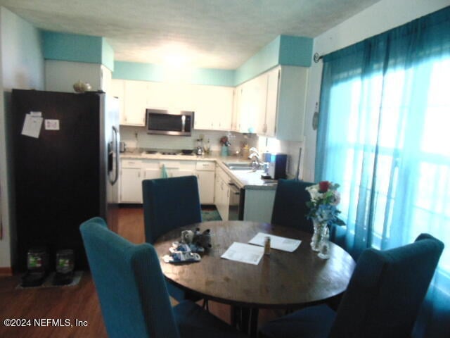 dining room featuring sink and dark hardwood / wood-style flooring