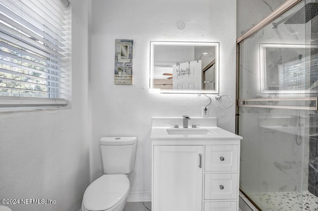 bathroom featuring vanity, toilet, and a shower with shower door