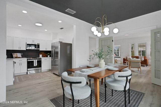 dining room featuring light hardwood / wood-style flooring and a chandelier