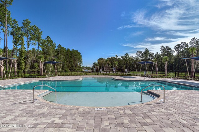 488 Coastline Way, Saint Augustine, FL 32092 - community pool featuring a patio area, fence, and view of wooded area