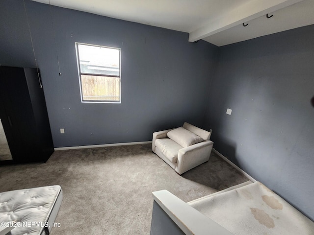 unfurnished room with beamed ceiling, baseboards, and carpet flooring