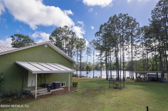 view of yard with central AC unit and a water view