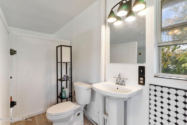 bathroom with toilet and a textured ceiling