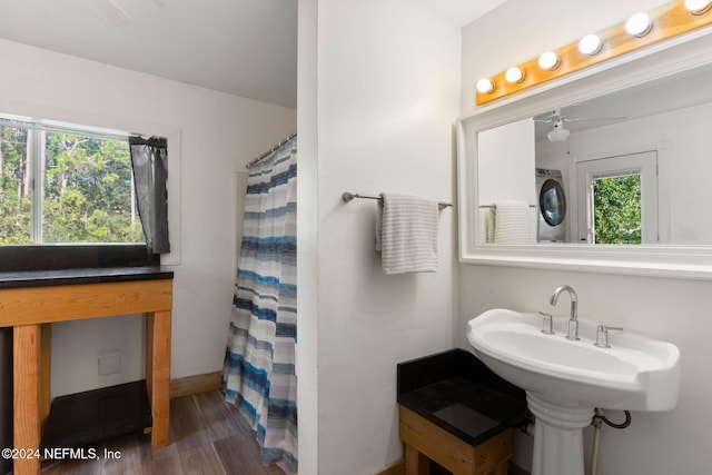 bathroom with ceiling fan, stacked washer and dryer, plenty of natural light, and hardwood / wood-style floors