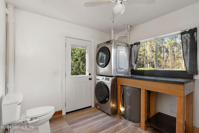 clothes washing area with light hardwood / wood-style floors, stacked washing maching and dryer, and ceiling fan