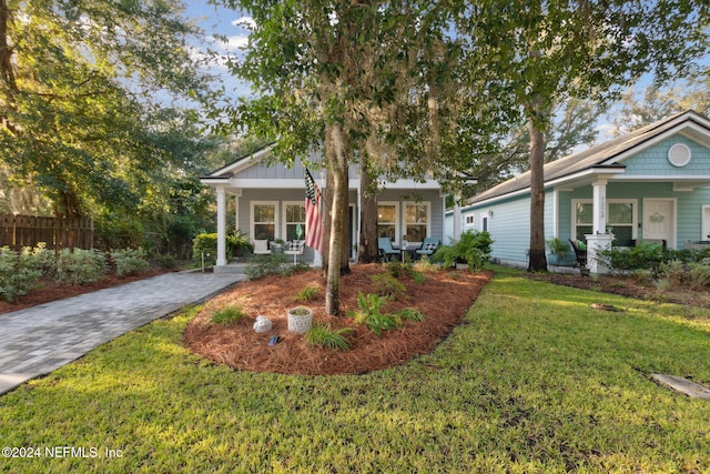 view of front of house with a front yard and covered porch