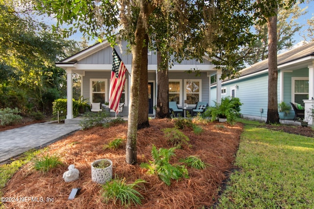 view of front of house with covered porch and a front lawn