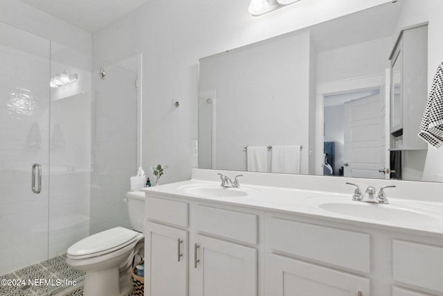 bathroom featuring vanity, toilet, and an enclosed shower