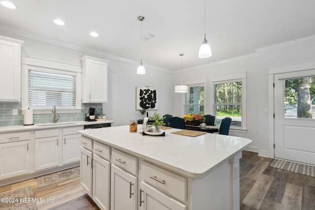 kitchen featuring white cabinets, sink, decorative light fixtures, and hardwood / wood-style floors