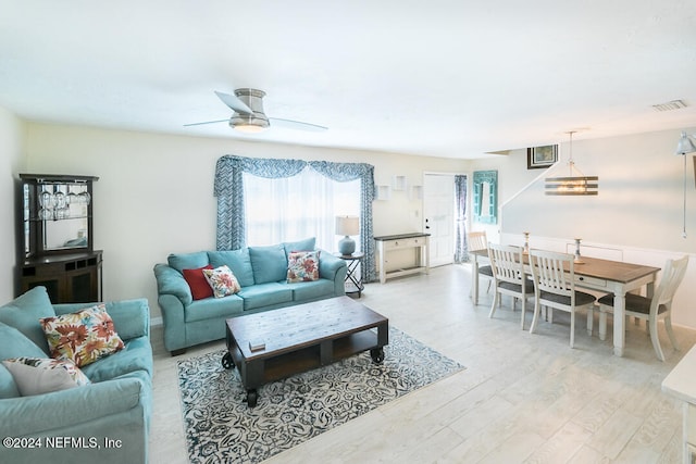 living room with light hardwood / wood-style flooring and ceiling fan