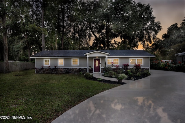 ranch-style home featuring a lawn