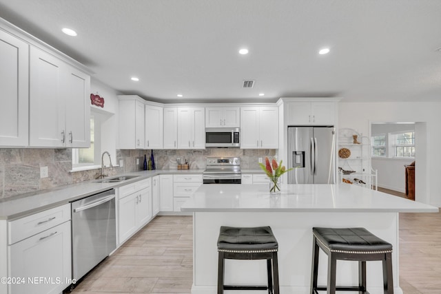 kitchen featuring appliances with stainless steel finishes, light hardwood / wood-style flooring, and a kitchen breakfast bar