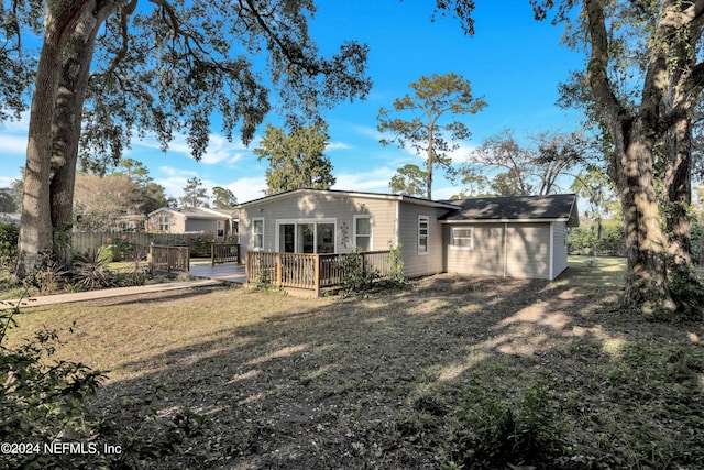 back of property featuring a deck and a lawn