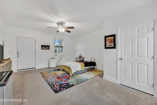 carpeted bedroom featuring a textured ceiling and ceiling fan