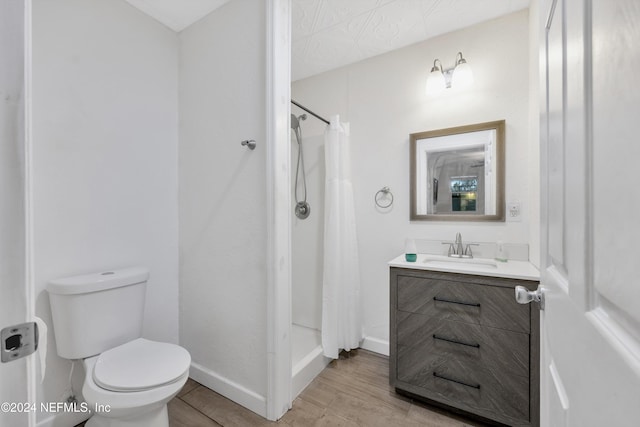 bathroom with vanity, toilet, hardwood / wood-style flooring, and a shower with curtain