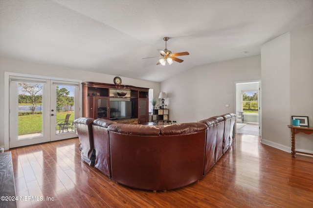 living room with a wealth of natural light, french doors, vaulted ceiling, and dark hardwood / wood-style floors