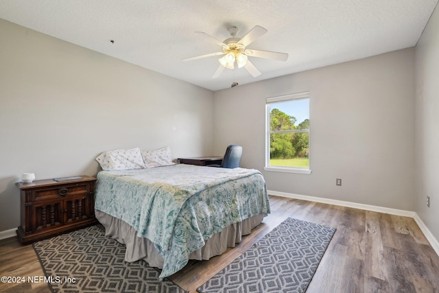 bedroom featuring hardwood / wood-style floors, a textured ceiling, and ceiling fan