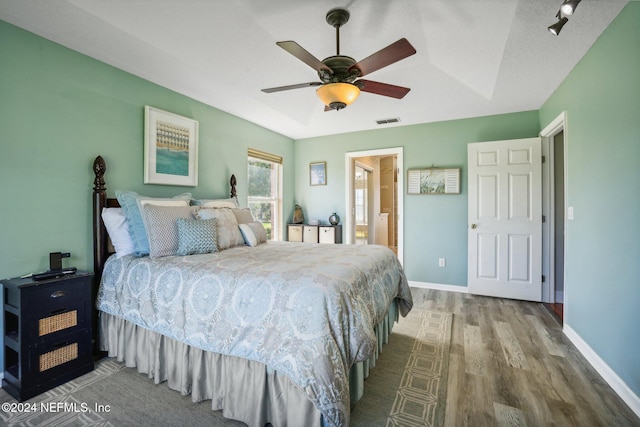 bedroom featuring hardwood / wood-style flooring, connected bathroom, and ceiling fan