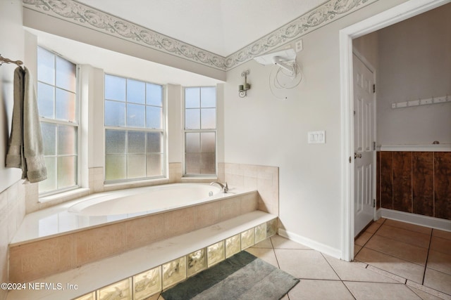 bathroom with a relaxing tiled tub, plenty of natural light, and tile patterned flooring