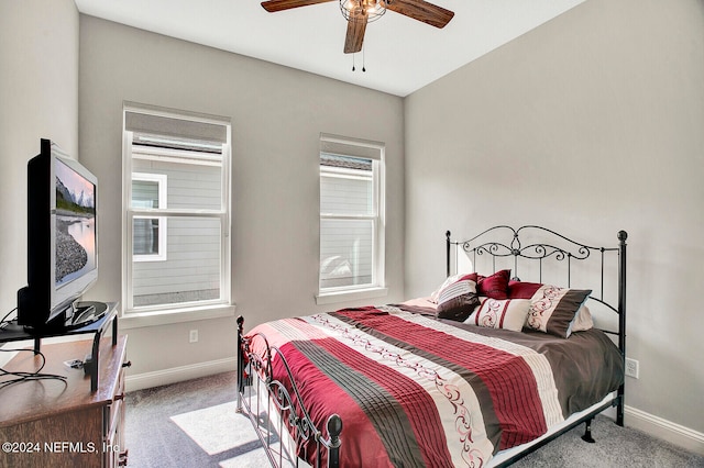 bedroom featuring light carpet, a ceiling fan, and baseboards