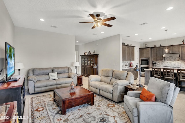 living room featuring a textured ceiling and ceiling fan