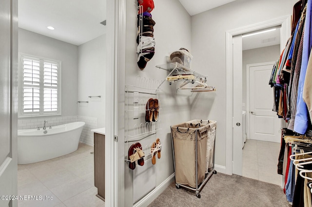 full bath with a freestanding bath, tile patterned floors, vanity, and visible vents