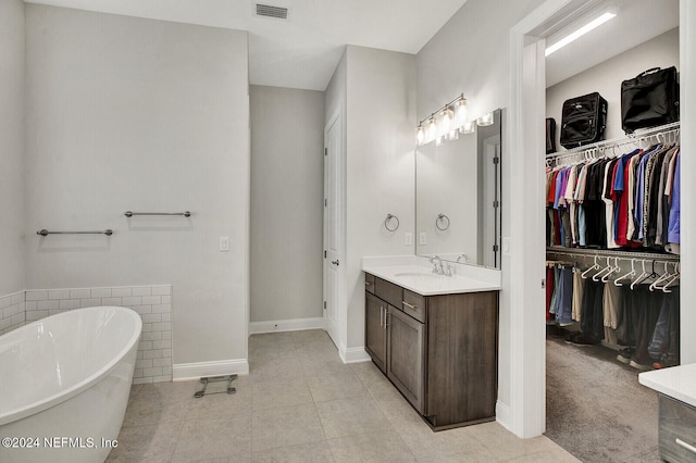 bathroom with vanity, a bath, and tile patterned flooring