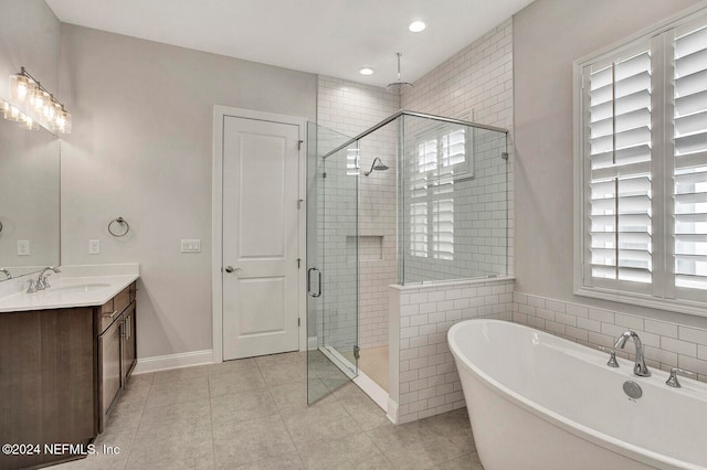 bathroom featuring vanity, plus walk in shower, and tile patterned flooring