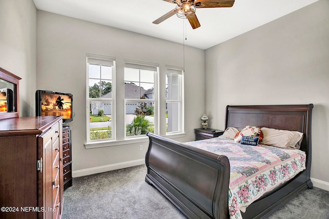 bedroom featuring baseboards, light colored carpet, and ceiling fan