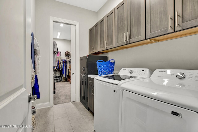 washroom featuring light tile patterned flooring, cabinets, and separate washer and dryer