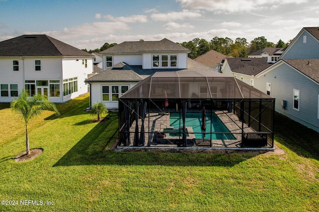 back of property featuring a patio, a lawn, and glass enclosure