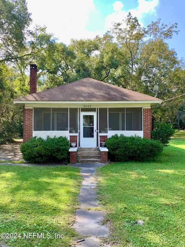 ranch-style house featuring a front yard and a sunroom