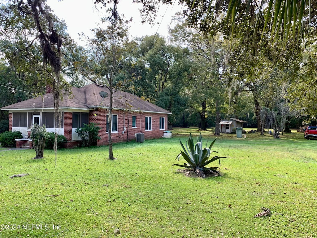 view of yard with central AC and a storage unit