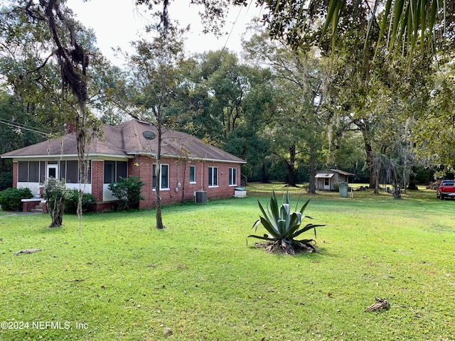 view of yard with central AC and a storage unit