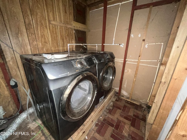 laundry room with washer and clothes dryer and wooden walls