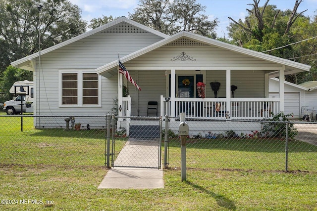 bungalow-style house featuring covered porch and a front yard