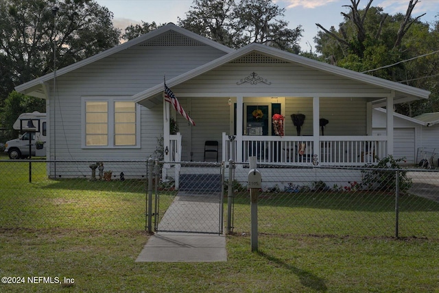 bungalow with a porch and a front lawn