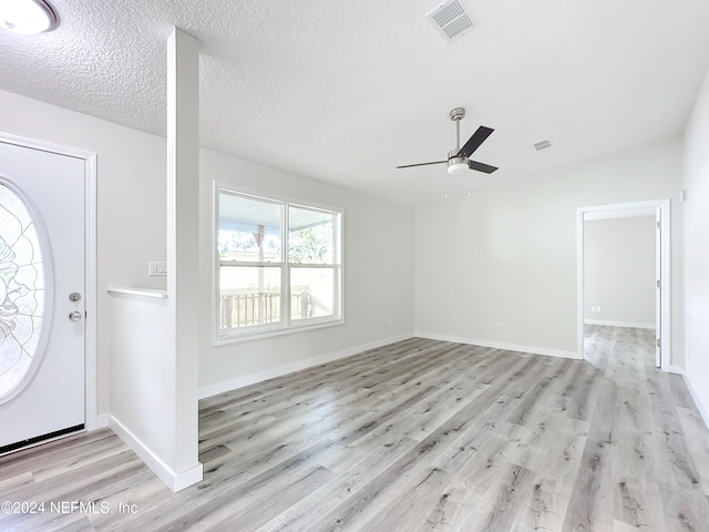 foyer with ceiling fan, a textured ceiling, and light hardwood / wood-style flooring