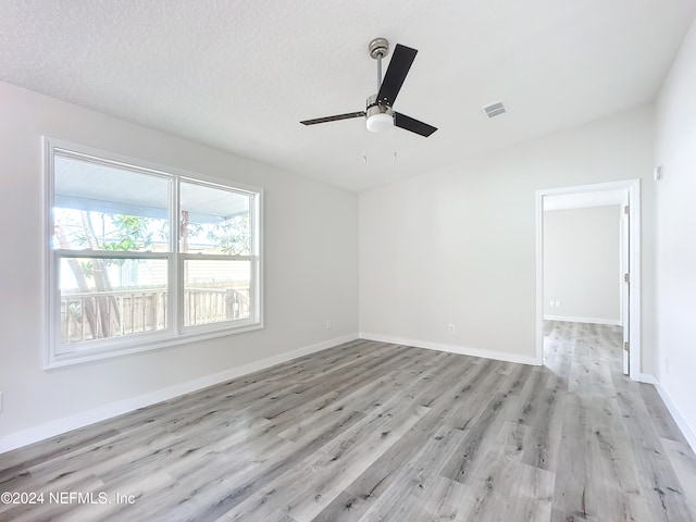 unfurnished room with light hardwood / wood-style flooring, a textured ceiling, and ceiling fan