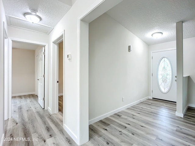 foyer with a textured ceiling and light hardwood / wood-style floors