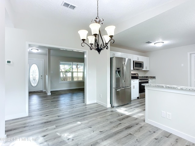 kitchen with white cabinetry, appliances with stainless steel finishes, light hardwood / wood-style flooring, and hanging light fixtures