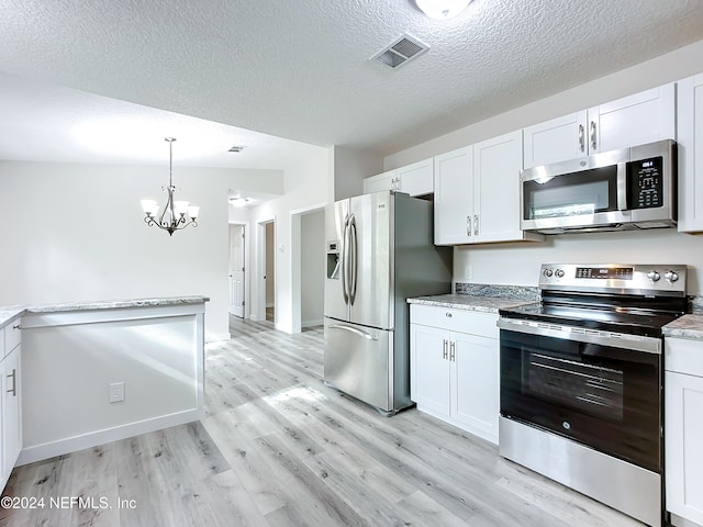 kitchen with lofted ceiling, appliances with stainless steel finishes, and white cabinets