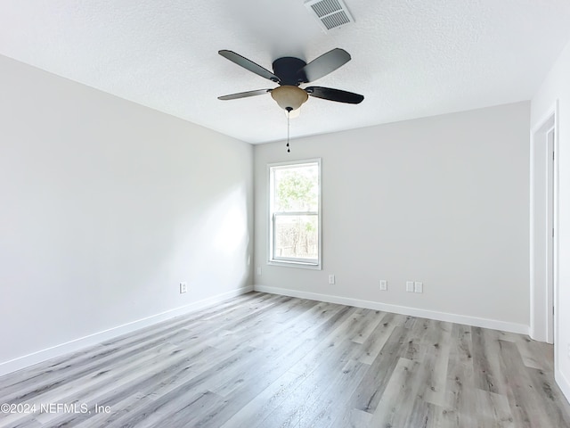 unfurnished room with ceiling fan, a textured ceiling, and light wood-type flooring