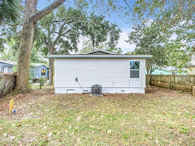 view of side of home featuring a yard and central AC