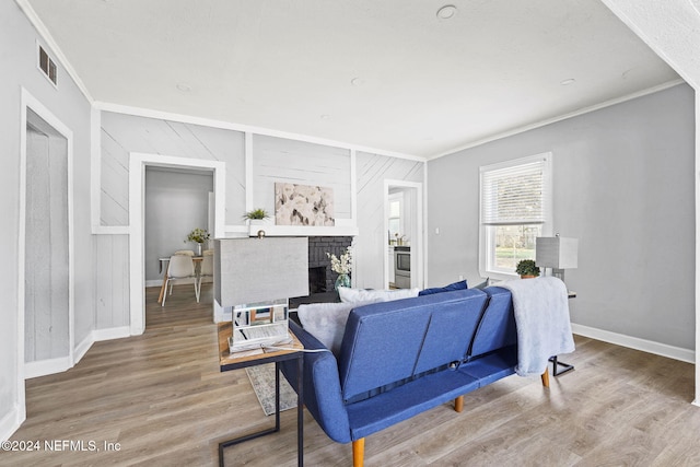 living room featuring a fireplace, crown molding, hardwood / wood-style floors, and wooden walls