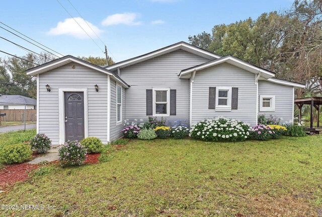 view of front of house featuring fence and a front lawn