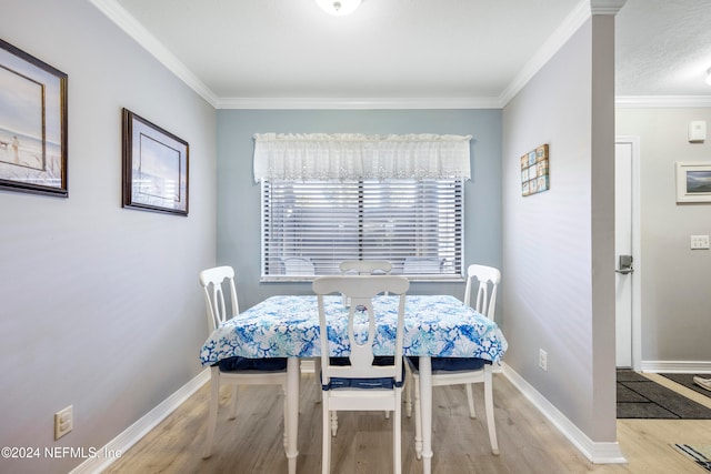 dining room with light hardwood / wood-style flooring and ornamental molding