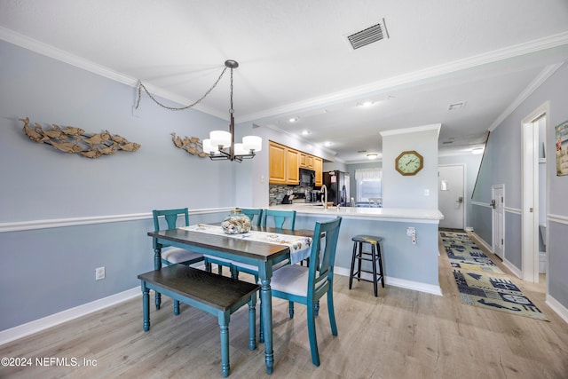 dining area featuring a chandelier, light hardwood / wood-style floors, and ornamental molding