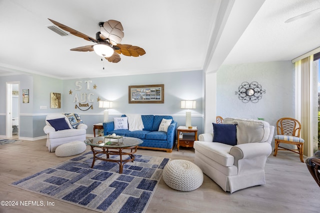 living room with hardwood / wood-style floors, ornamental molding, and ceiling fan