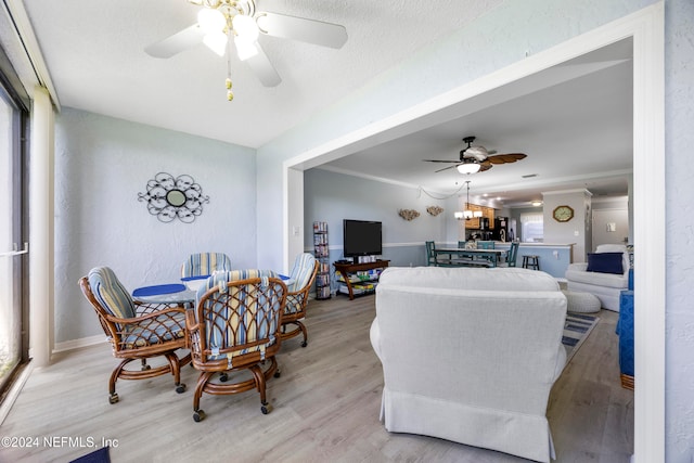 dining room with a textured ceiling, light hardwood / wood-style floors, ceiling fan, and crown molding